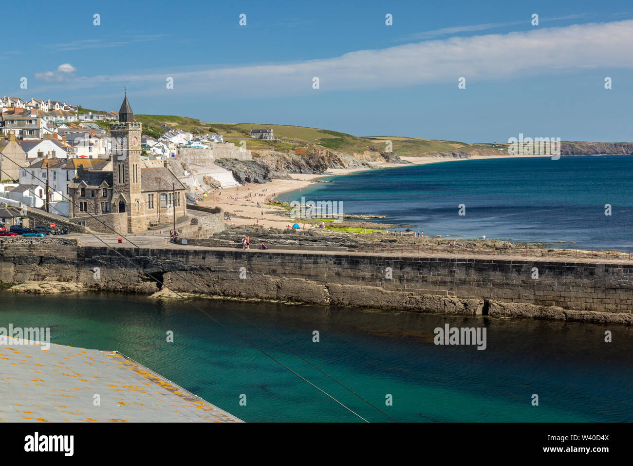 Das seaside Harbour Village von Camborne, Cornwall, England, zeigt die Hafenmauer und Kirche. Stockfoto