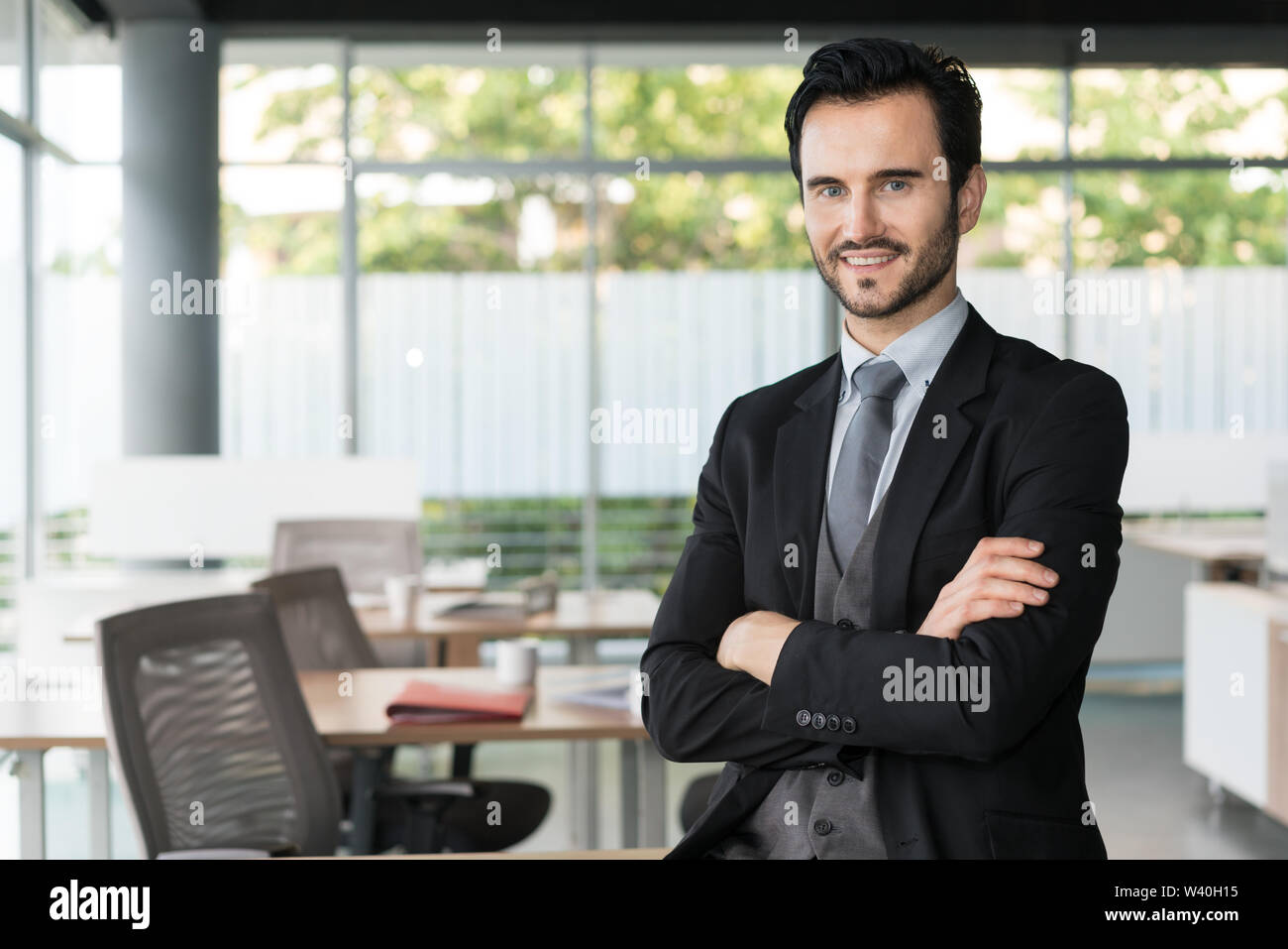 Glücklich der Mann, der mit den Armen im Büro gekreuzt. Stockfoto