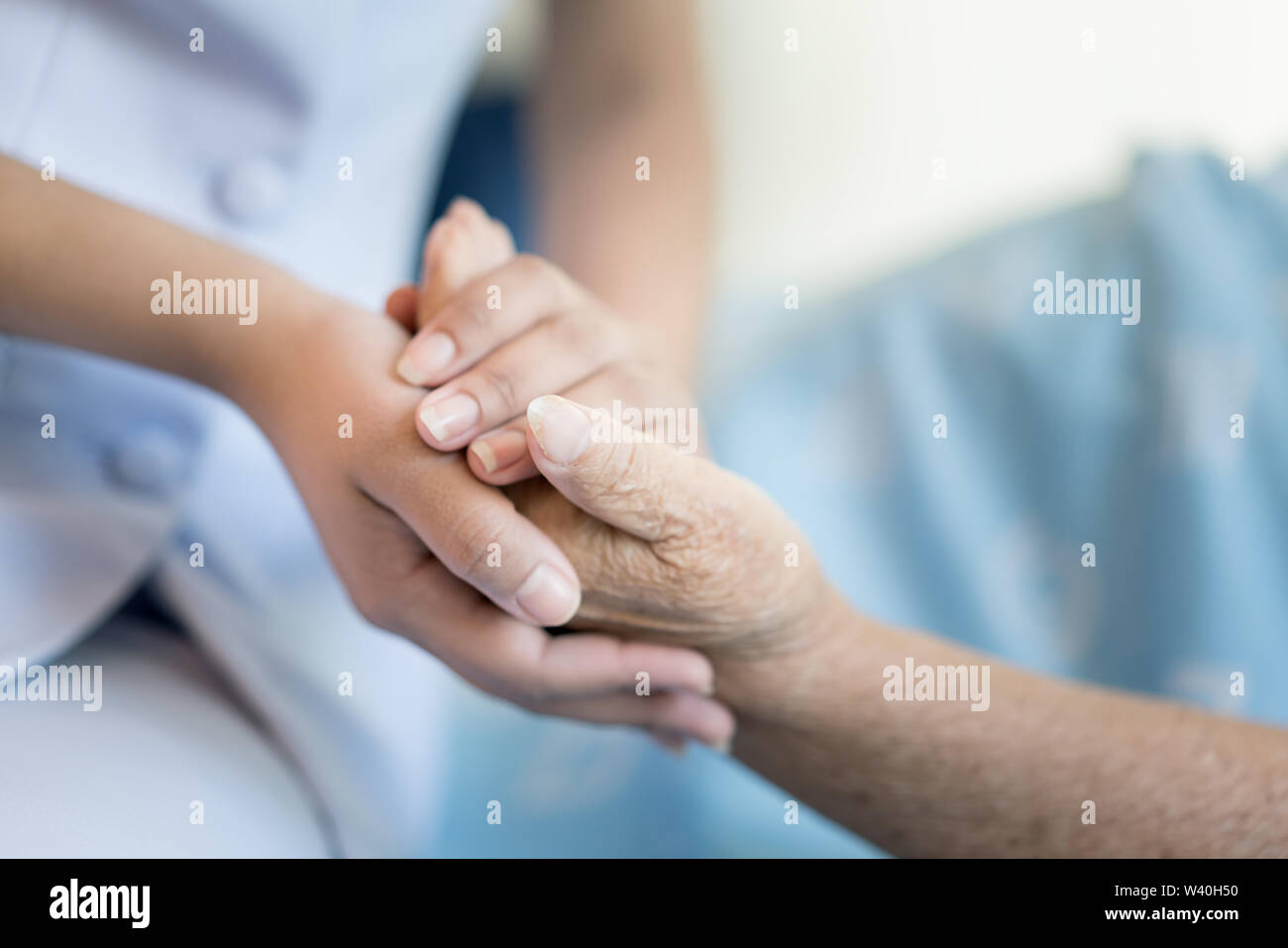 Krankenschwester Sitzen Auf Einem Krankenhausbett Neben Eine Altere Frau Helfende Hande Die Altenpflege Konzept Stockfotografie Alamy