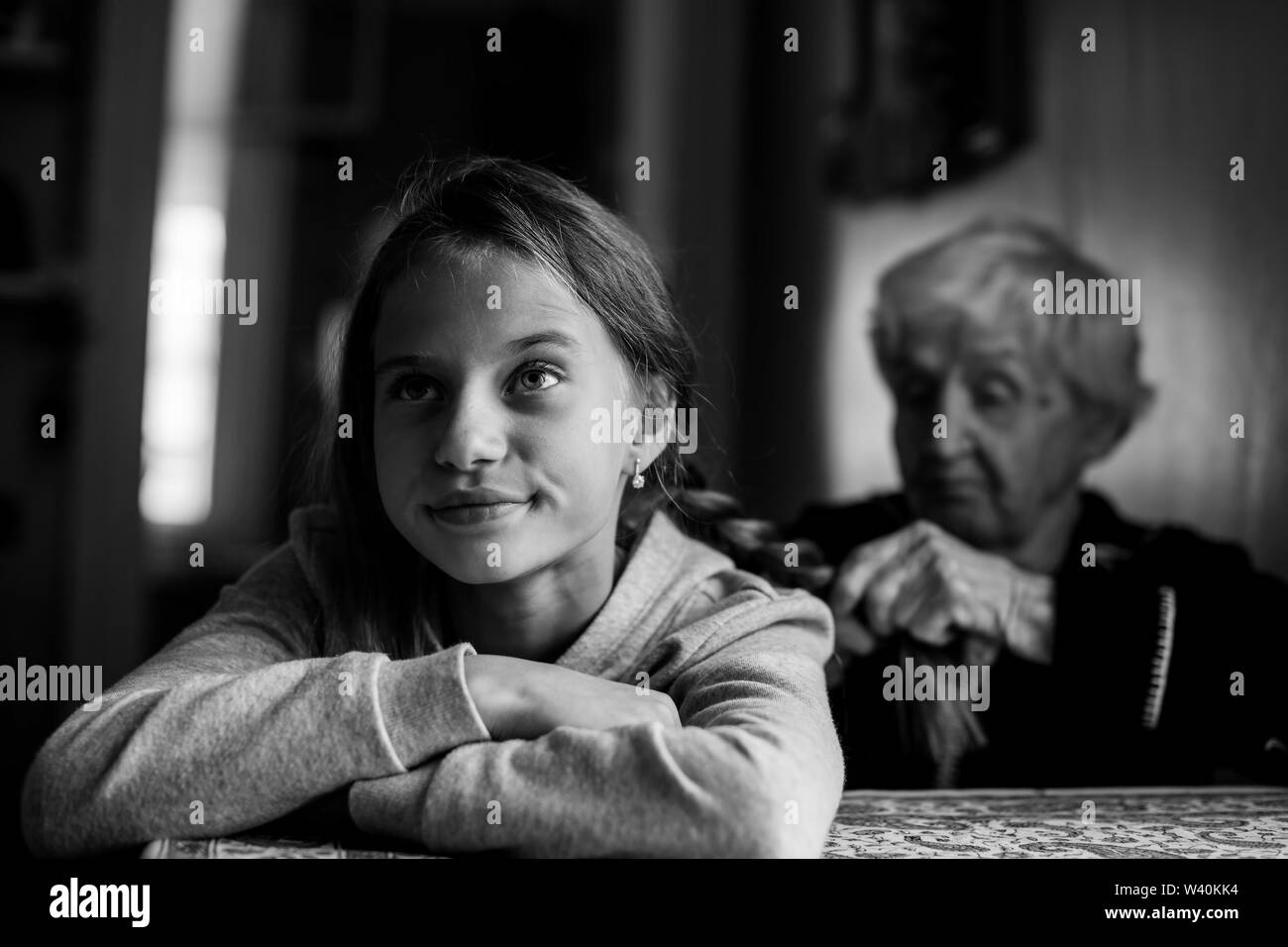 Eine ältere Frau Geflechte ihre Enkelin Haar. Schwarz-weiß Foto. Stockfoto