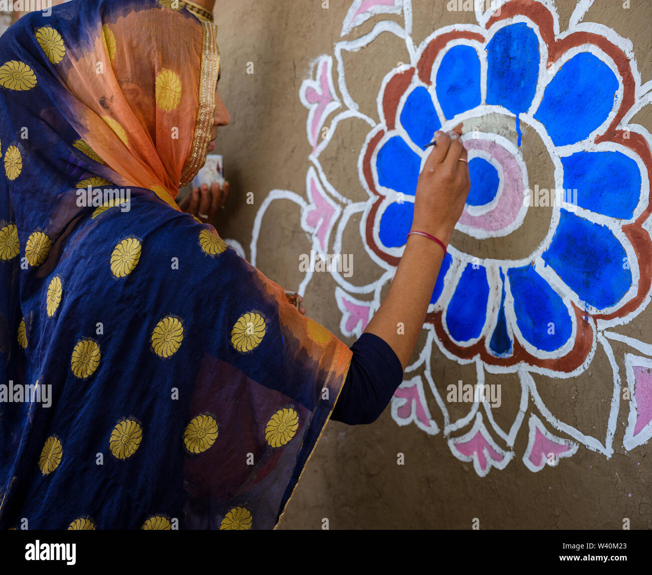 PUSHKAR, INDIEN - ca. November 2018: Indische Frau Malerei indischen Designs bei einem Wettbewerb in der Pushkar Camel Fair. Es ist eines der weltweit größten Stockfoto
