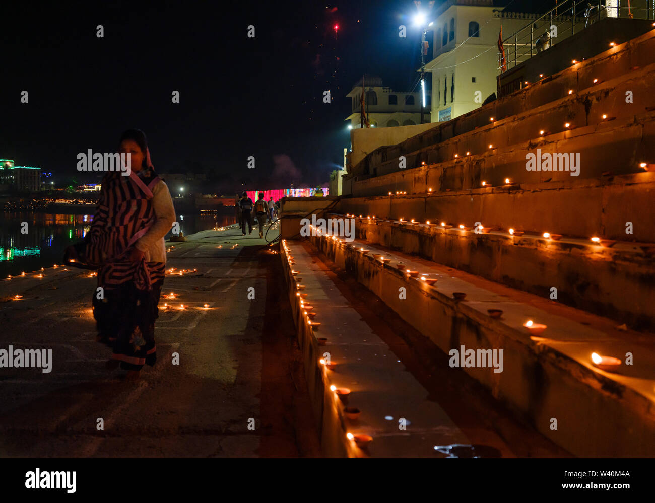 PUSHKAR, INDIEN - ca. November 2018: Frau wandern in den Pushkar Ghats während der Eröffnungsfeier der Camel Fair. Es ist eines der weltweit Lar Stockfoto
