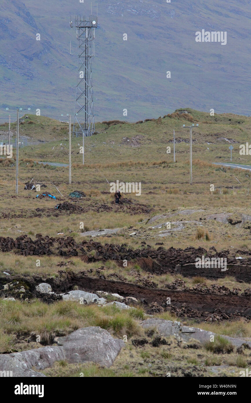 Man schneiden Torf sods in einem Torf im Westen Irlands in der Nähe von Delphi in der Grafschaft Galway Moor. Stockfoto