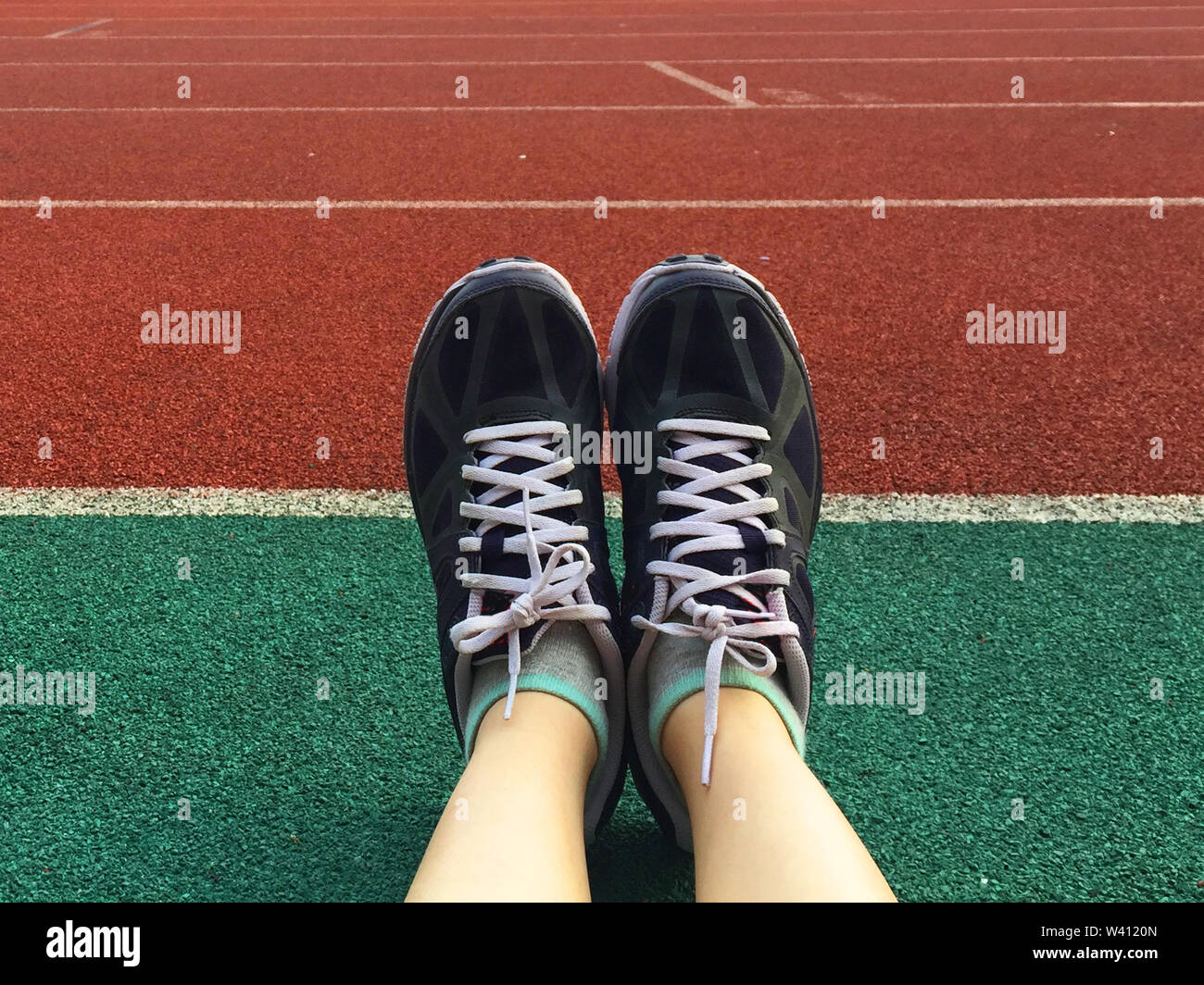 Runner Füße laufen auf Stadium. Close-up auf Frau Beine und Sneakers in Bewegung. Sport Konzept. Selfie Lila Sport Schuhe auf dem laufenden Feld für Fi Stockfoto