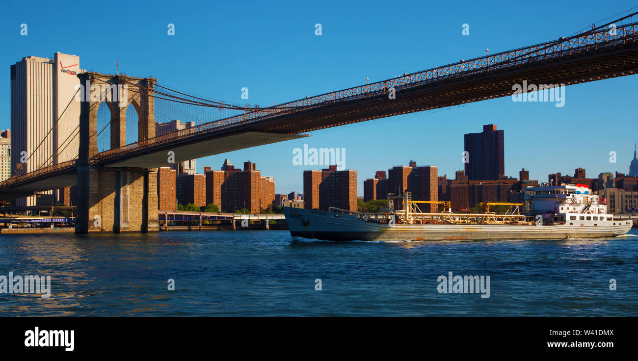 Frachtschiff vorbei unter der Brooklyn Bridge Stockfoto