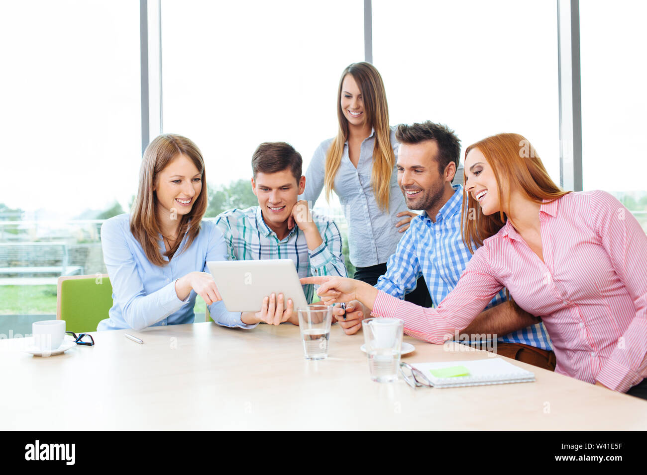 Gruppe von Menschen, die in Büro- und Sitzen am Tisch Stockfoto