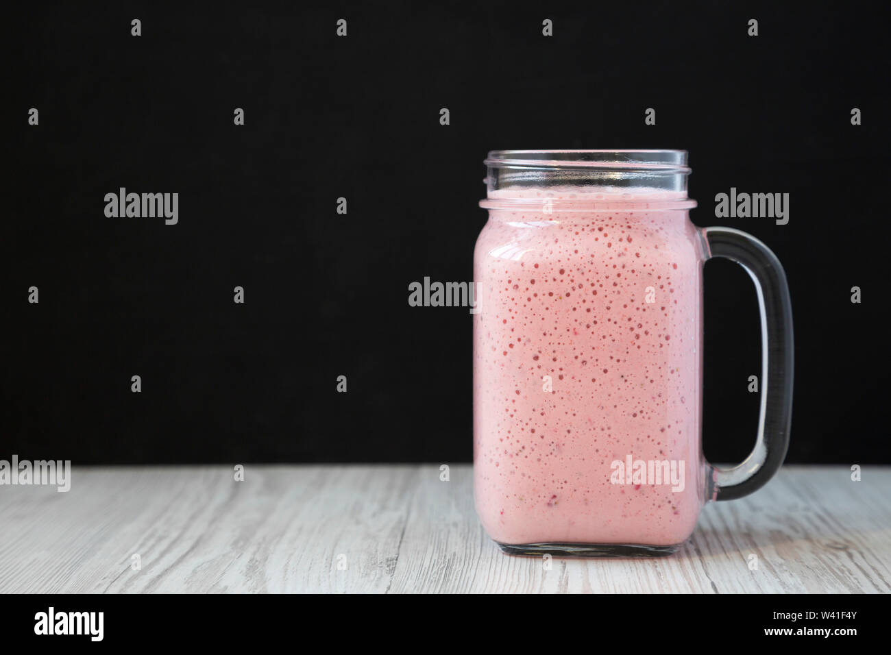 Strawberry Banana Smoothie in einem Glas, Seitenansicht. Platz für Text. Stockfoto