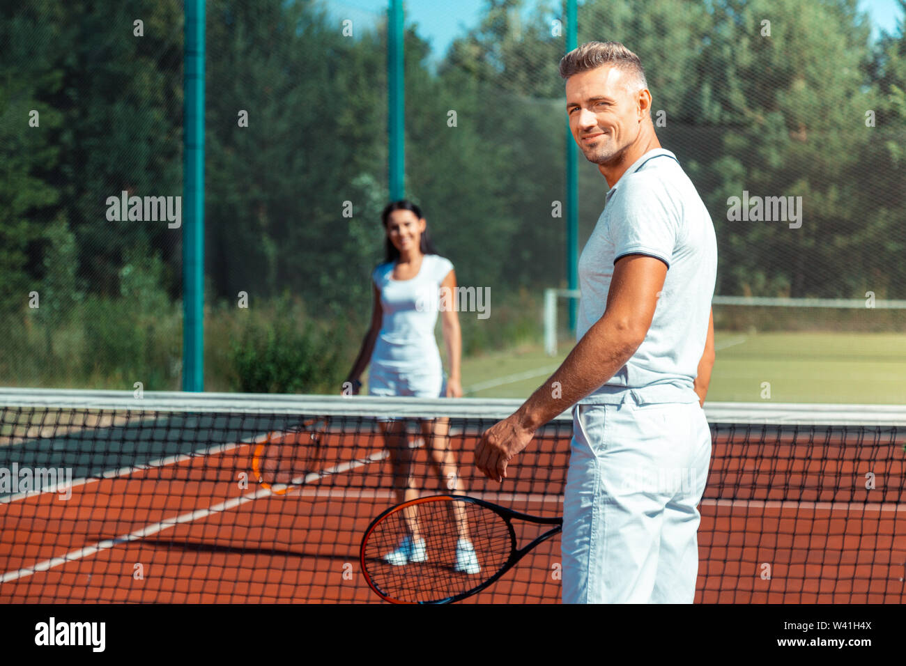 Strahlende Ehemann Gefühl Super Tennis spielen mit Frau Stockfoto