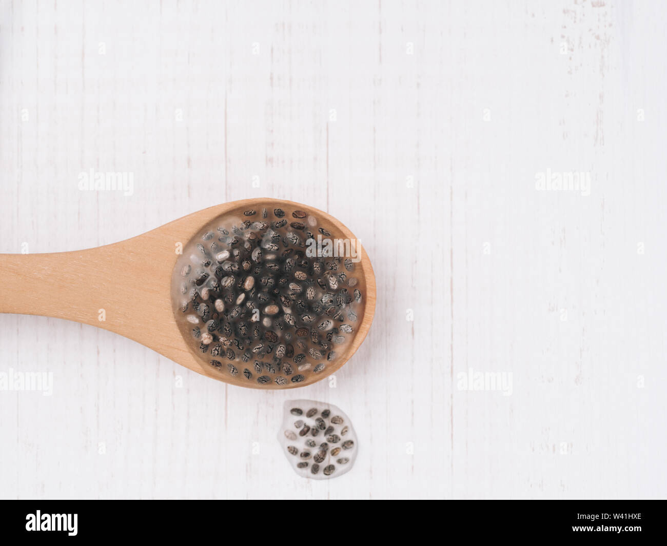 Wet Samen oder Chia Chia-Ei in hölzernen Löffel auf weißem Holz- Hintergrund. Eiersatzprodukte, Eiern, veganern austauschen Eier Konzept Raum für Text kopieren. Stockfoto