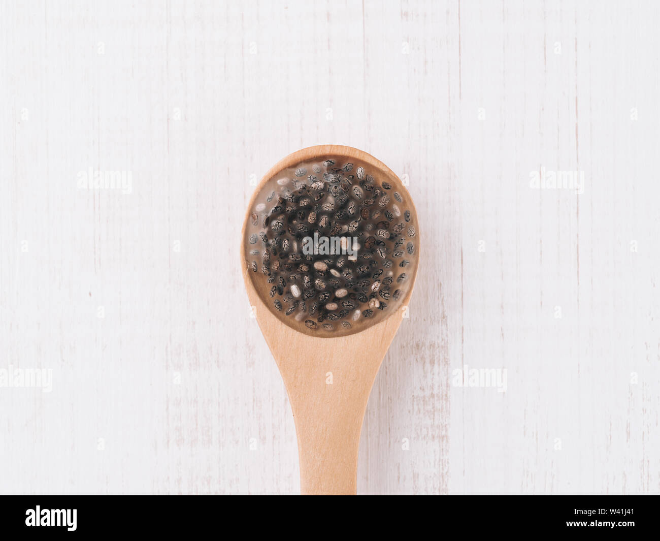 Wet Samen oder Chia Chia-Ei in hölzernen Löffel auf weißem Holz- Hintergrund. Eiersatzprodukte, Eiern, veganer Eier Konzept ersetzen Stockfoto