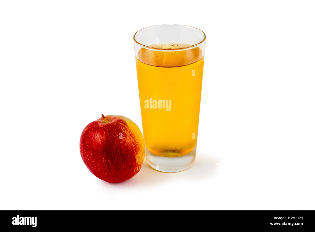 Auf weißem Hintergrund Apfelsaft in einem Glas neben einem Apfel. Stockfoto
