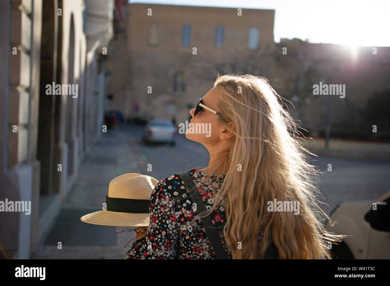 Junge blonde Frau zu Fuß auf Straßen in Valletta, Malta, Rückansicht Stockfoto