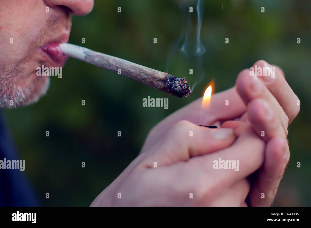 Mann raucht einen joint. Medizinische Verwendung von Marihuana und Legalisierung des Cannabis, leichte Drogen Konzept Stockfoto