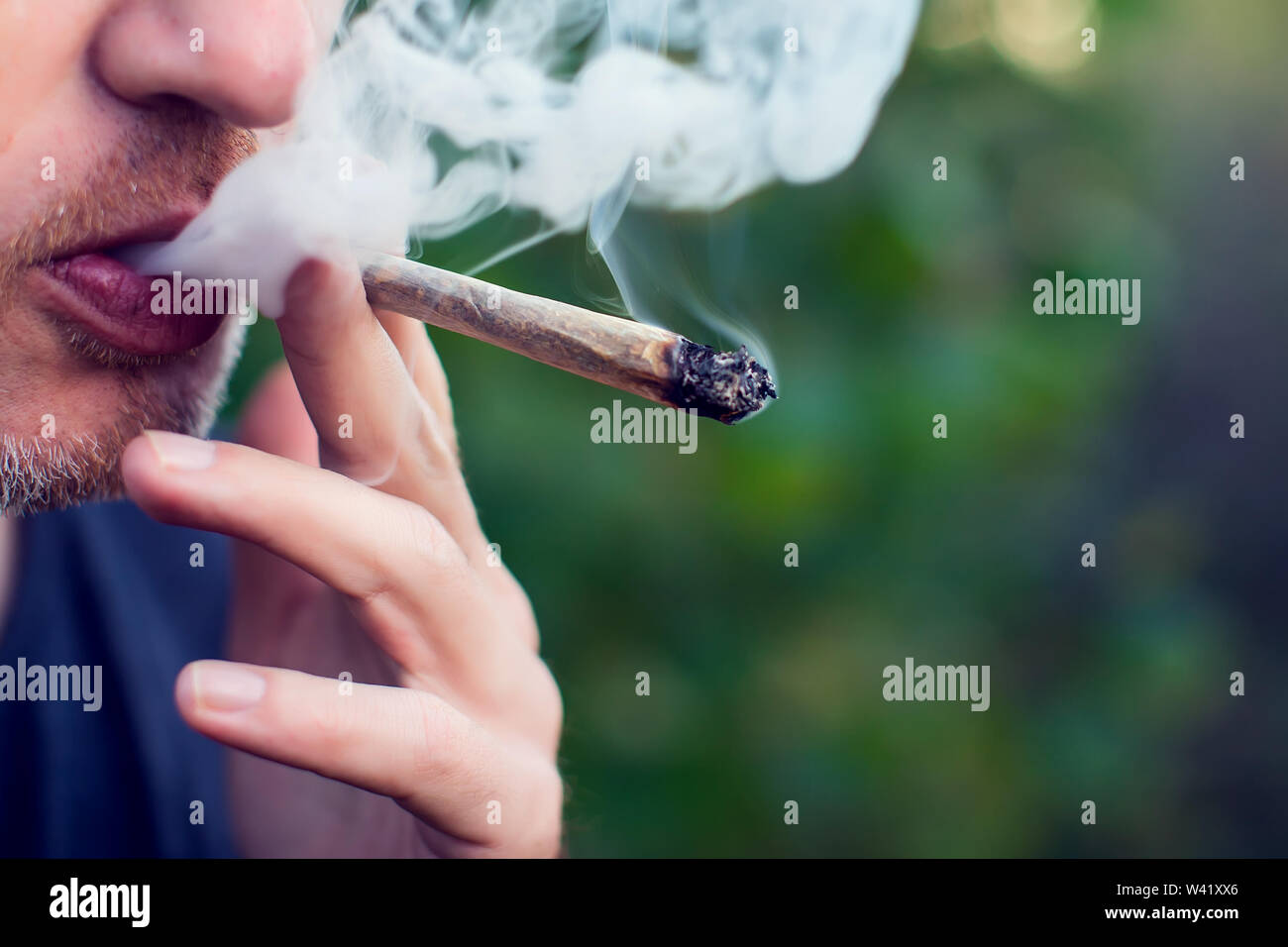 Mann raucht einen joint. Medizinische Verwendung von Marihuana und Legalisierung des Cannabis, leichte Drogen Konzept Stockfoto