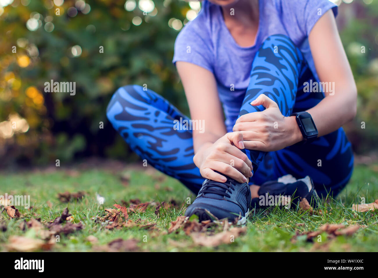 Frau Läufer, die ihr verletztes Bein Sport outdoor. Sport-, Medizin- und Personen Konzept Stockfoto