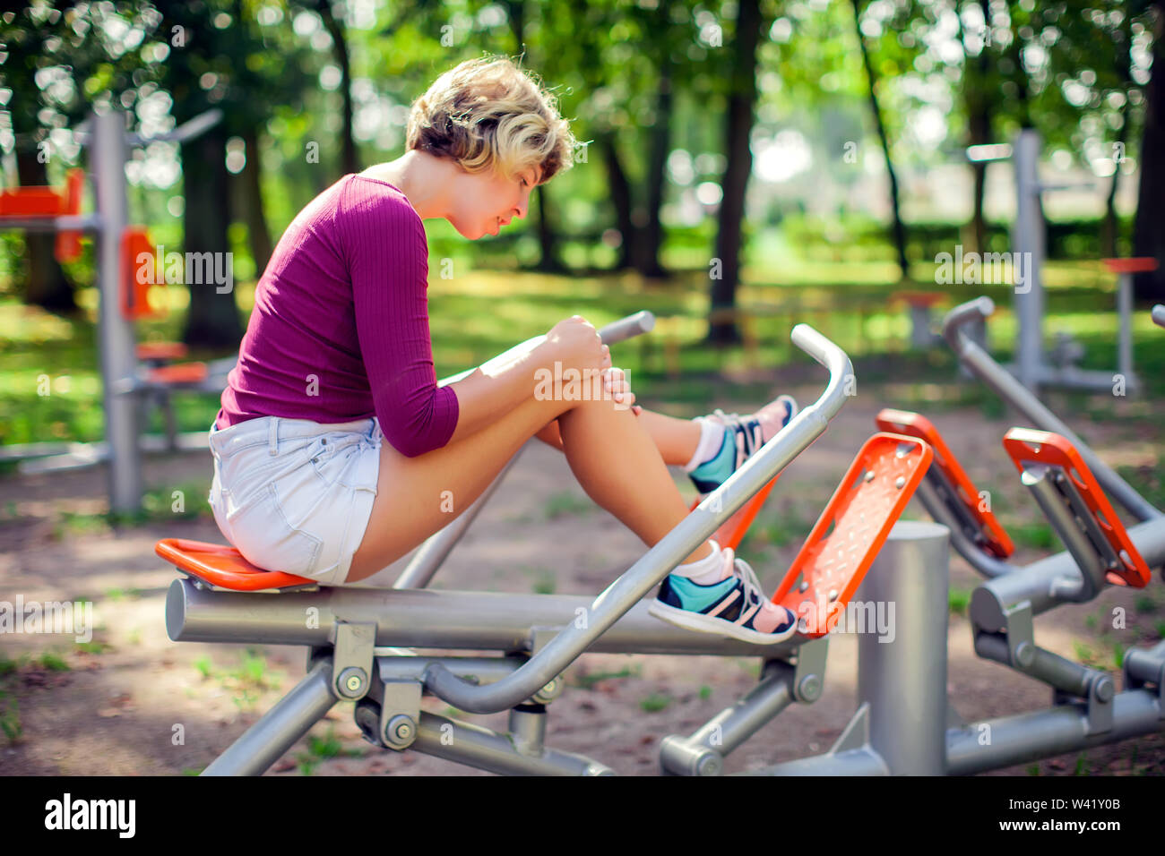 Junge unglückliche Frau Gefühl Schmerz in ihr Knie beim Sport Training im Park. Sport-, Medizin- und Personen Konzept Stockfoto