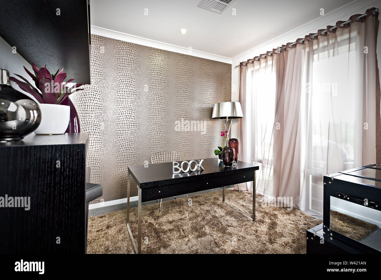Luxus arbeit Zimmer mit schwarzen Möbeln und Fell Teppich neben einem  glänzend Silber Leuchte, Vase und Vorhang auf für die Windows  Stockfotografie - Alamy