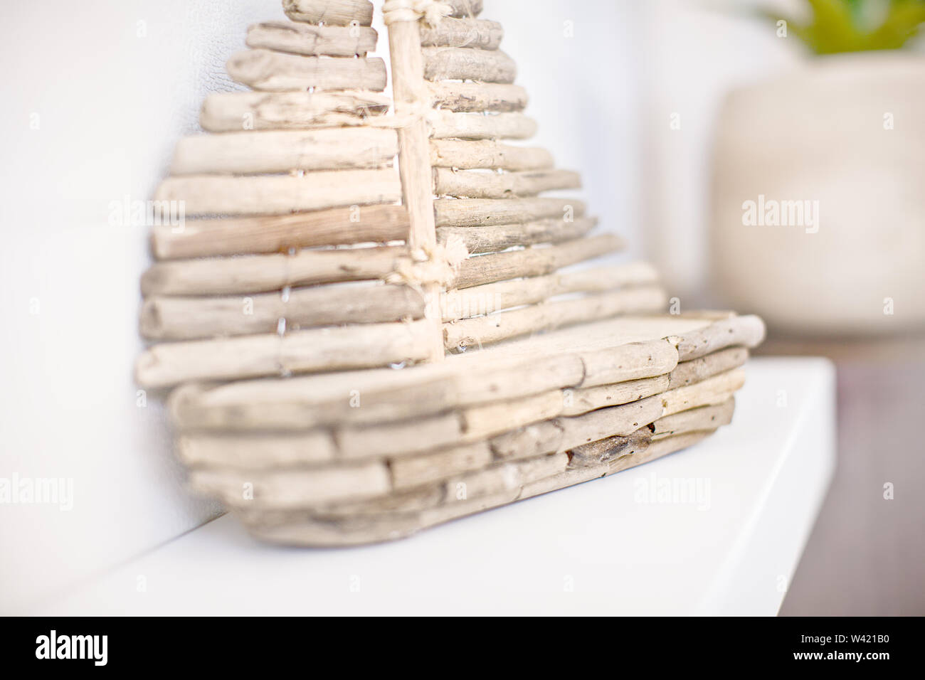 Holz- stick Schiff Klein, bis auf die unscharfen schließen Zähler in einem Innenraum eines modernen Hauses, die Wand rack Holding die Geschenkartikel Stockfoto
