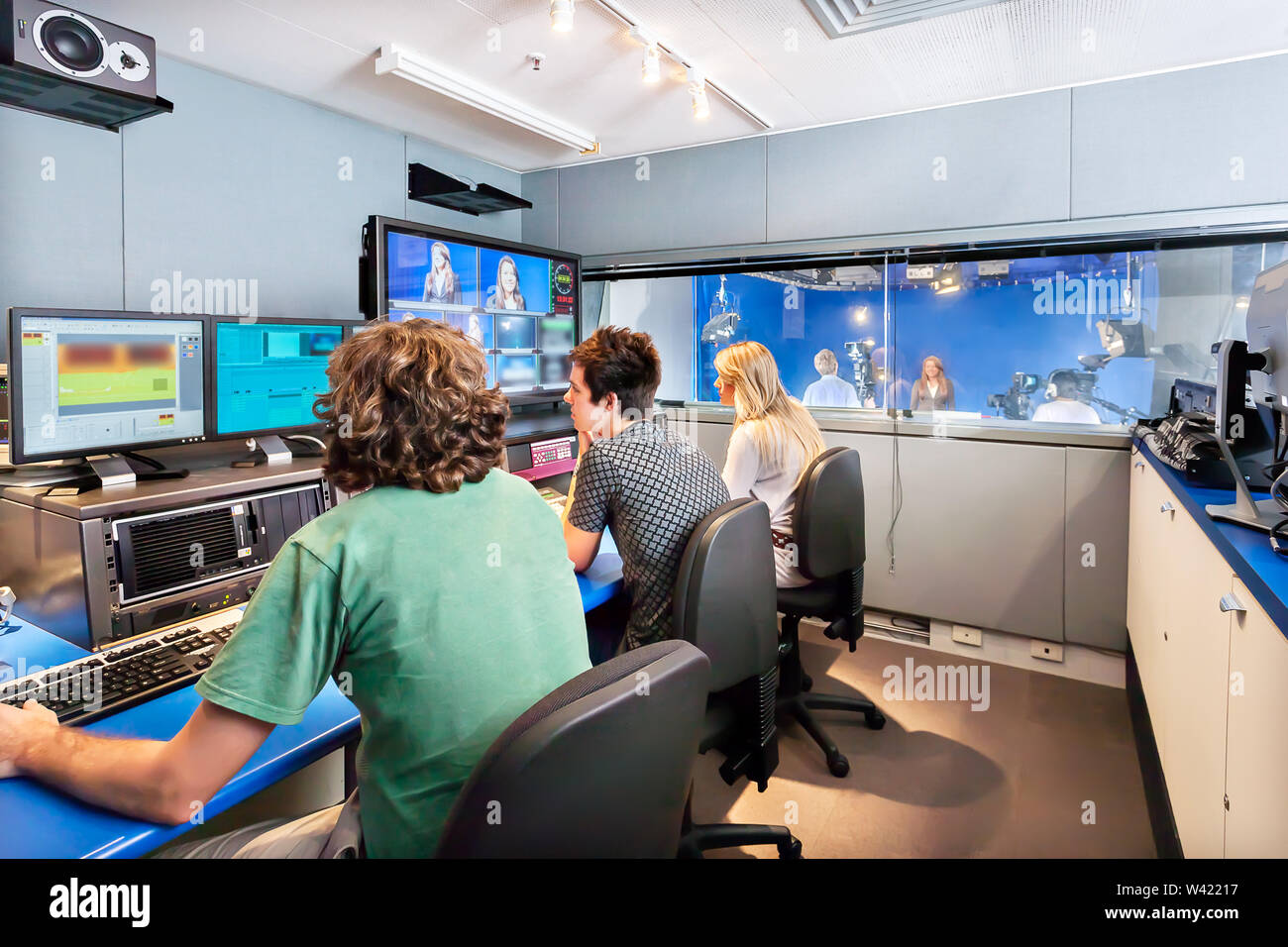 Jungen und Mädchen sind der Arbeit in einem Studio mit Bildschirmen und Mischer für Broadcast ein Fernsehprogramm Stockfoto