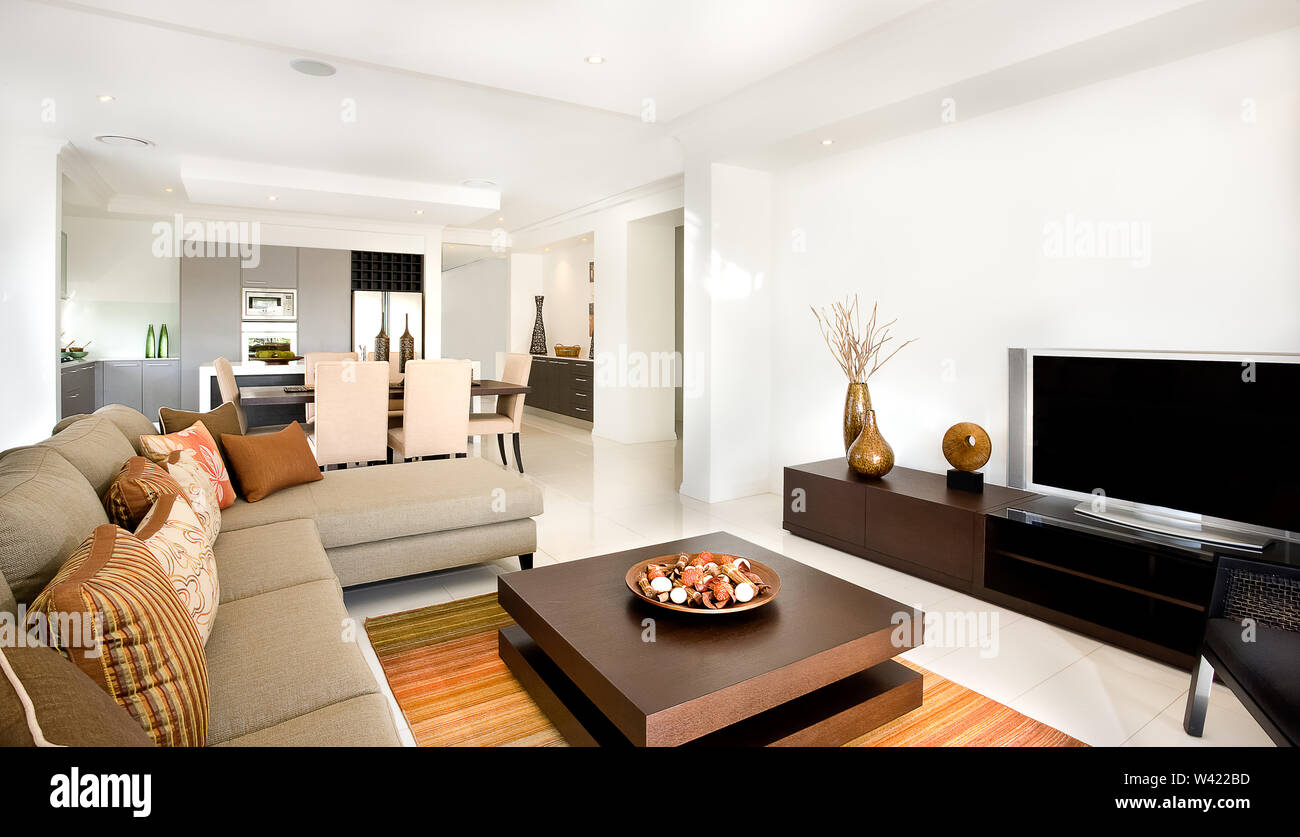 Es gibt Sofas und Stühle mit Kissen in der modernen Wohnzimmer mit einem kreativen Holztisch mit Ornamenten Elemente auf. Lange Schrank oder TV st Stockfoto