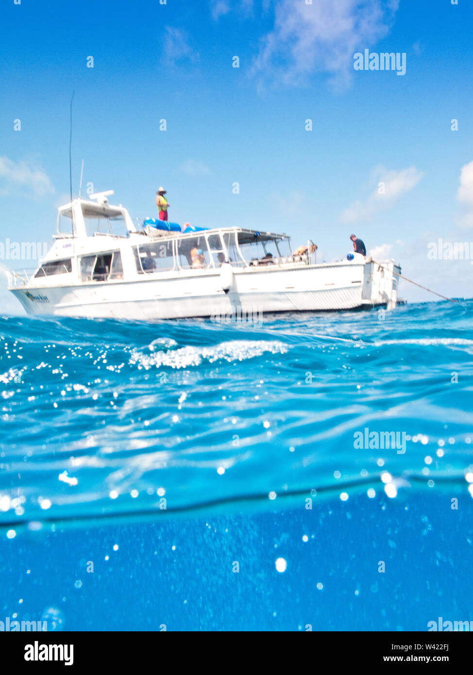 Eine Yacht auf dem Meer mit Menschen an Bord an einem sonnigen Tag Stockfoto