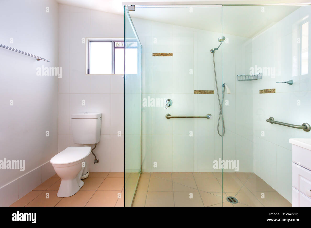 Einfaches Badezimmer mit einer großen Dusche mit Glaswänden und Support Stockfoto