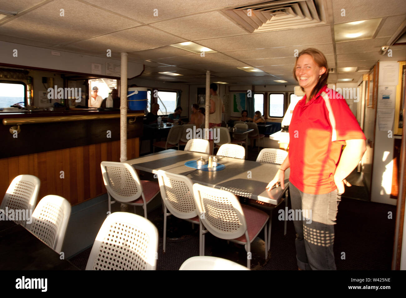 Eine Frau in der Essbereich einer Yacht lächelnd Stockfoto