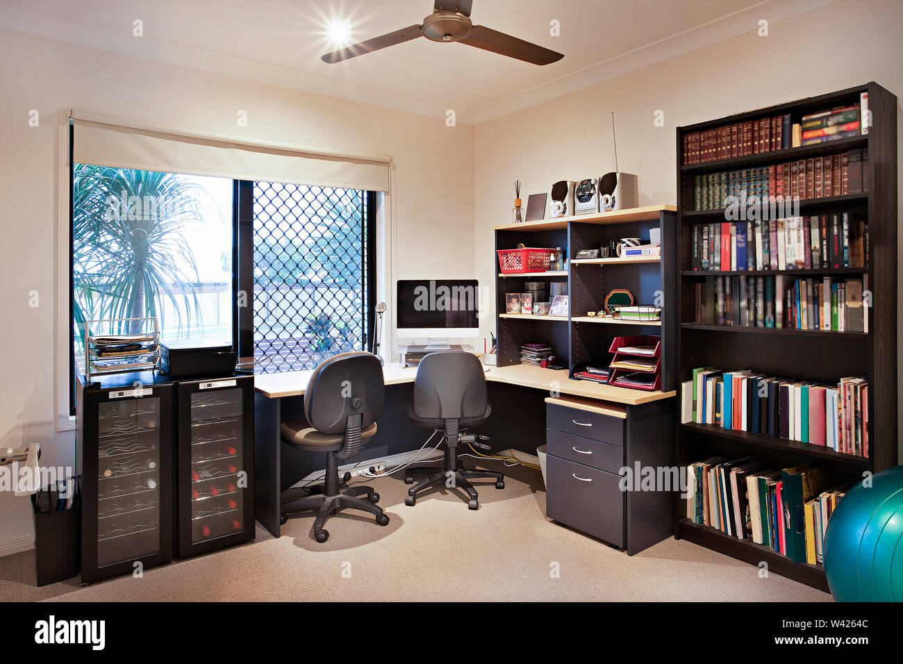 Arbeitszimmer mit Bücher und Computer, komfortable Möbel mit Designs, die Wände sind weiß, die Kissen auf Stühlen, innere Räume einer Wohnung. Stockfoto