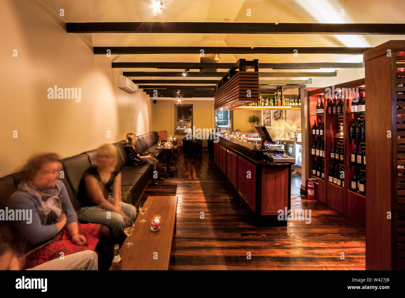Mädchen sitzen an bequemes Sofa, in der luxuriösen Club Area, Nächtliche Szene, perfekte Lichter auf Zimmer, Holz Fußboden und die Wände sind weiß Stockfoto