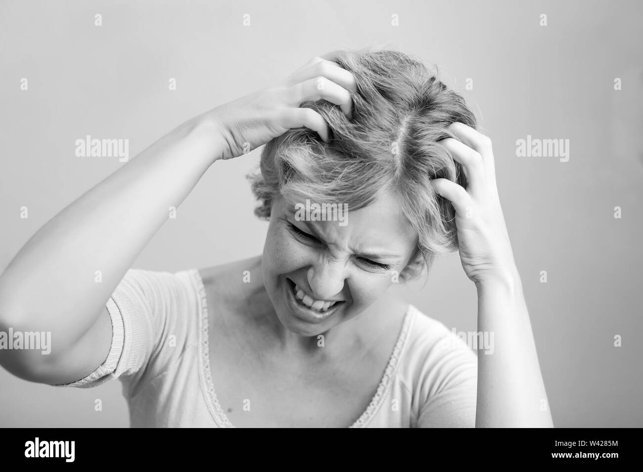 Frau Kratzen ihren Kopf auf weißem Hintergrund. Beschneidungspfade auf weißem Hintergrund Stockfoto
