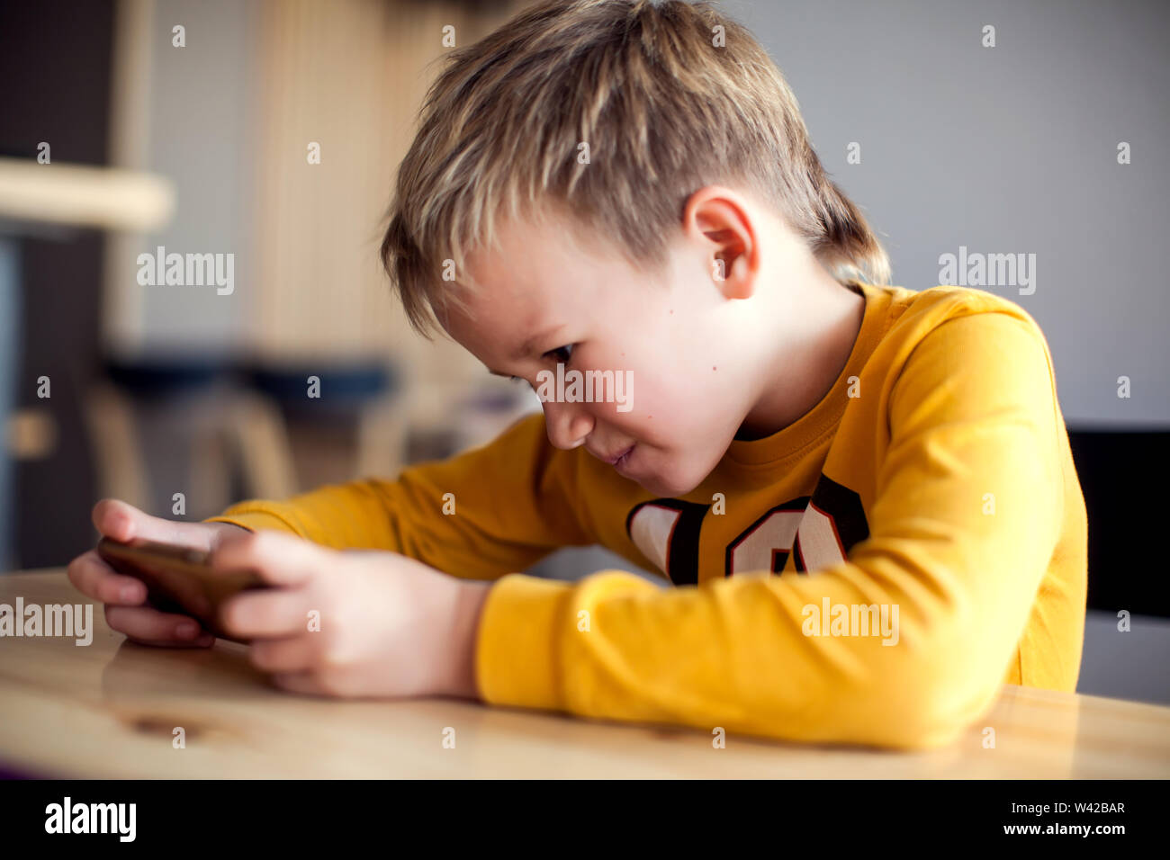 Kinder, Technologie und Internet Konzept. Wenig lächelnde Kind Junge spielen oder im Internet surfen auf digitalen Smartphone Stockfoto