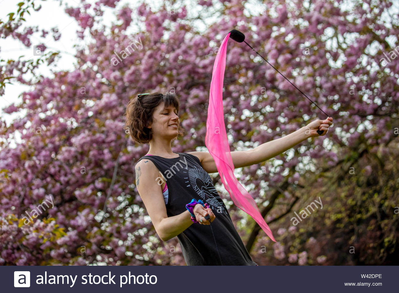 Eine junge Frau selbst genießen, während poi Spinning in Saint Stephen's Green, Dublin, der irischen Hauptstadt genießt schöne Wetter. Stockfoto