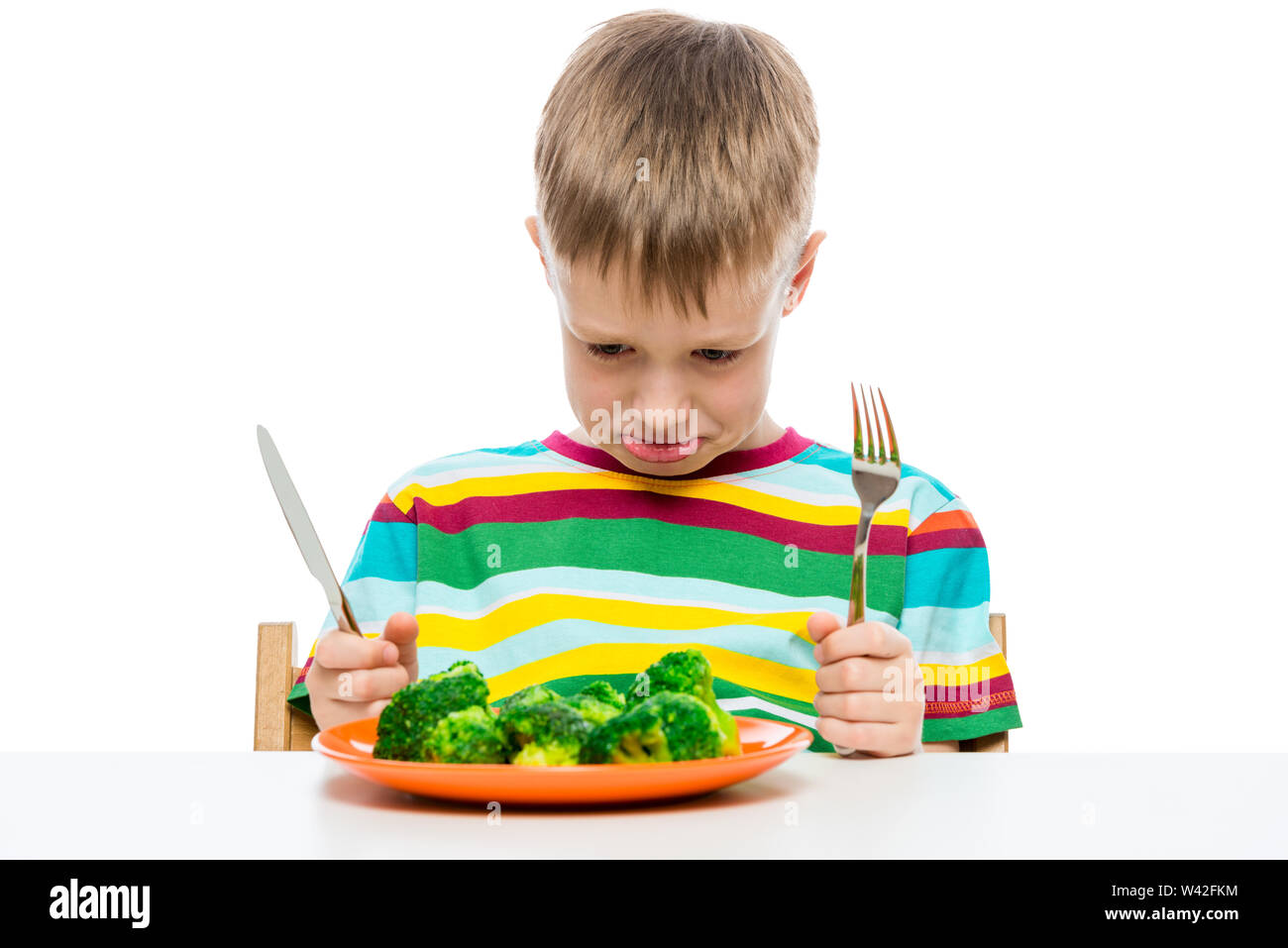 Emotionales Porträt eines Jungen, der nicht wie Brokkoli essen, Shooting im Studio Stockfoto