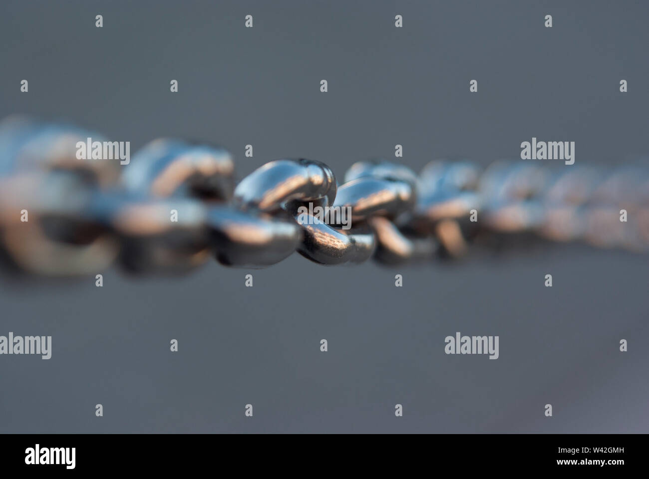 Edelstahl Kette gespannt, Fokus auf Mitte links, Rest absichtlich unscharf. Stockfoto