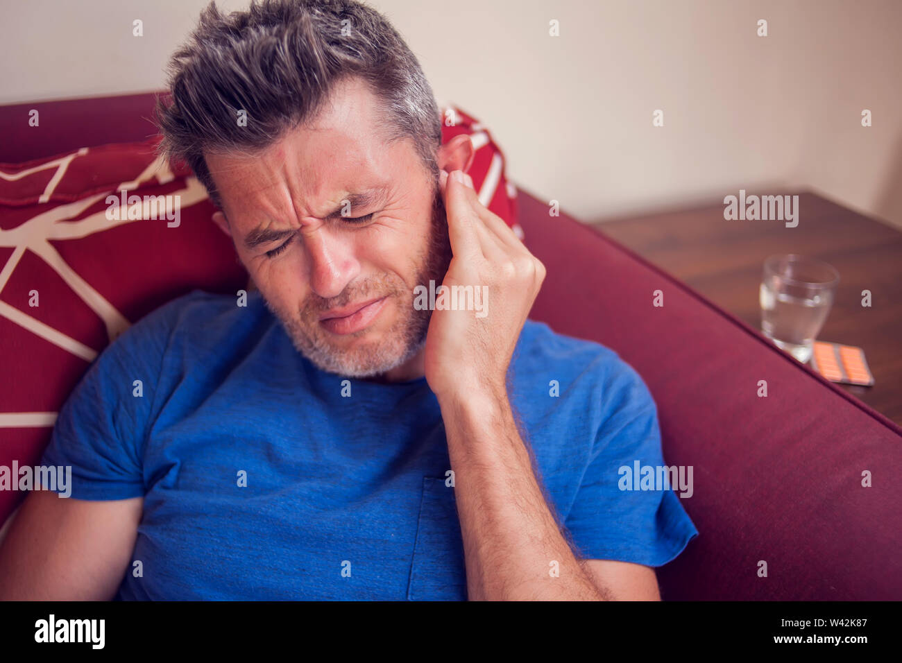 Mann fühlt sich starke Ohrenschmerzen zu Hause. Menschen, Gesundheitswesen und Medizin Konzept Stockfoto