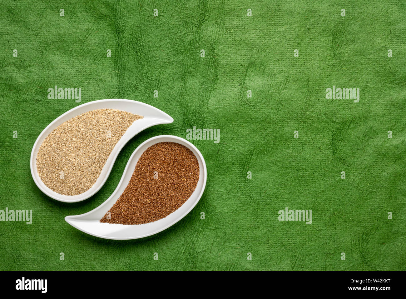 Glutenfreie Braun und Elfenbein teff Korn auf teardrop Form Schüssel gegen grüne strukturiertes Papier - wichtige Nahrungsmittel Getreide in Äthiopien und Eritrea Stockfoto