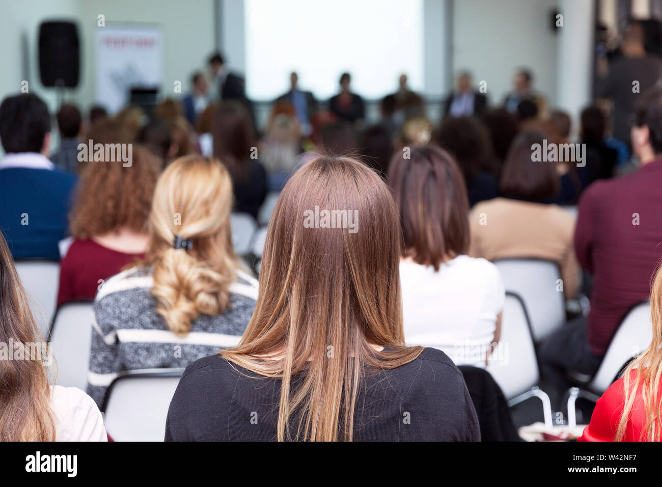 Die Teilnehmer an der geschäftlichen oder beruflichen Konferenz sitzen, hören auf die Lautsprecher Stockfoto