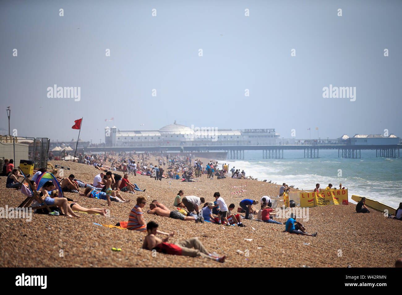 Die Menschen weiterhin die Sonne zu genießen trotz starkem Wind am Strand von Brighton, East Sussex. Mittwoch, den 20. Juli 2016. Stockfoto