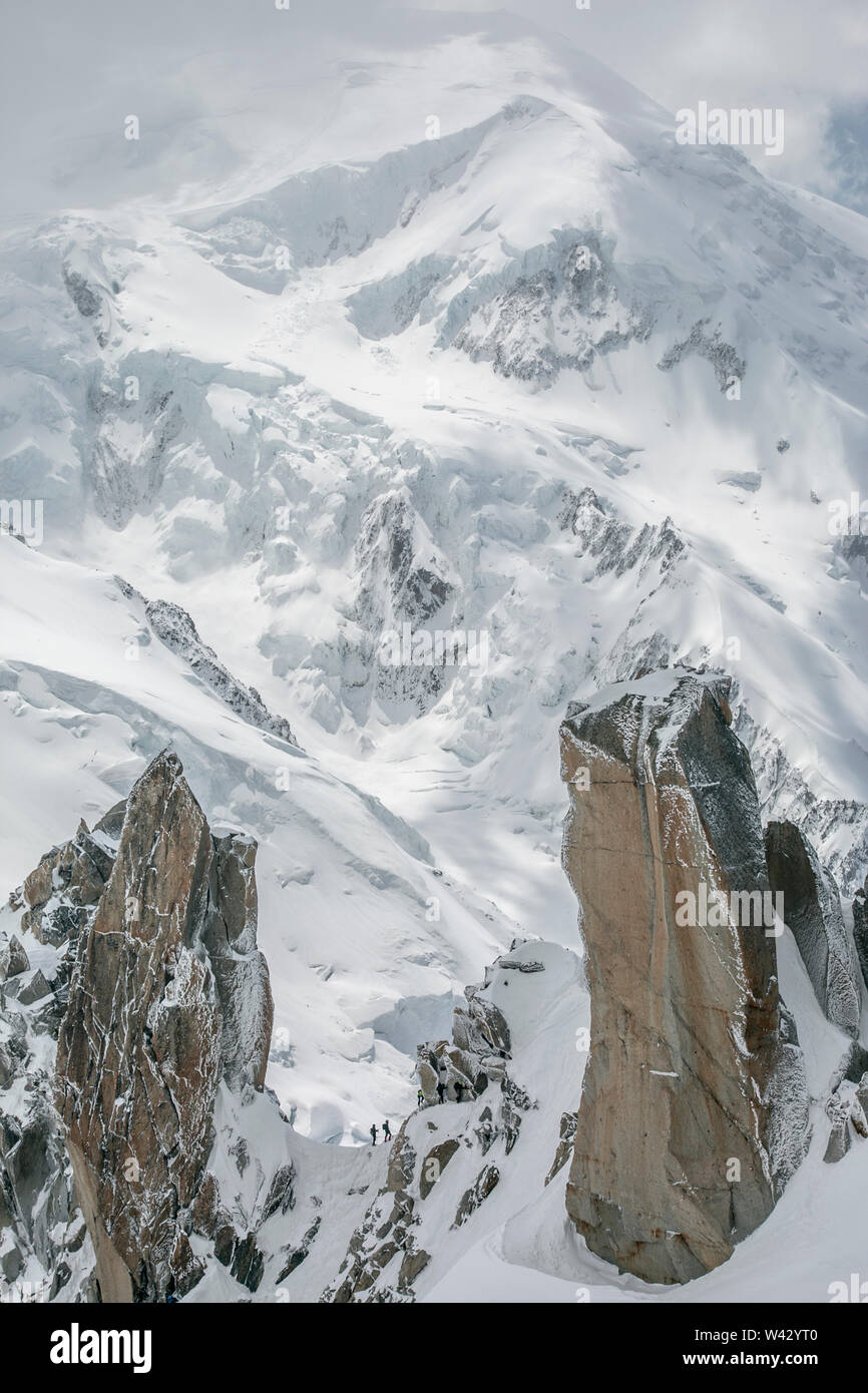 Zwei Alpinisten auf Cosmiques werden von Mt Blanc im Hintergrund in den Schatten gestellt Stockfoto