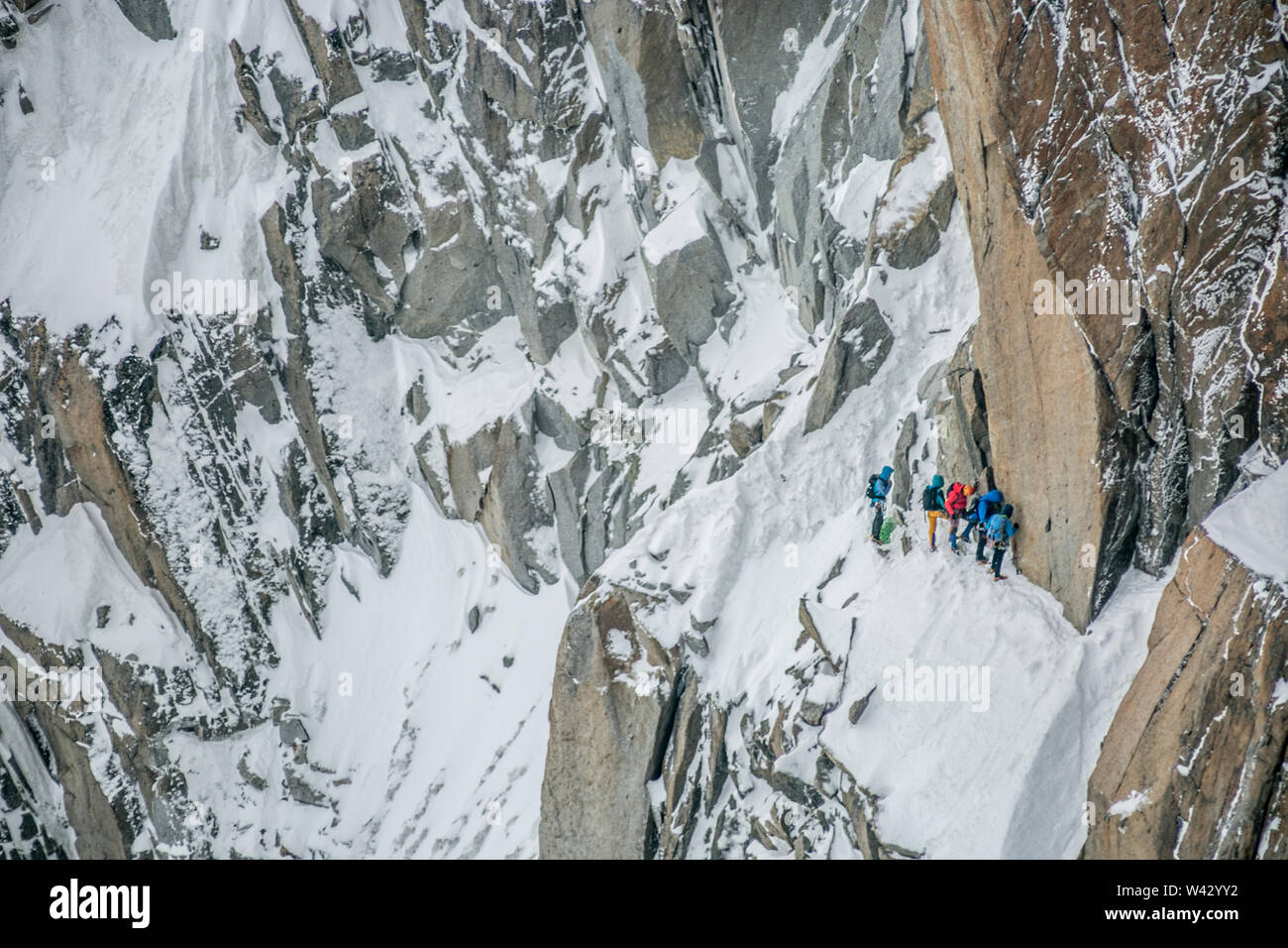 Eine Gruppe von Bergsteigern sammelt im steilen Gelände unter einem Gendarm Stockfoto