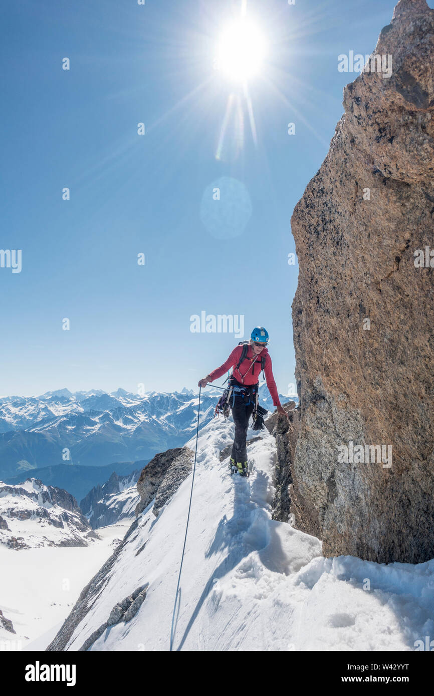 Ein alpinist Navigiert ein Schnee Traverse in perfekter Sommer Bedingungen Stockfoto