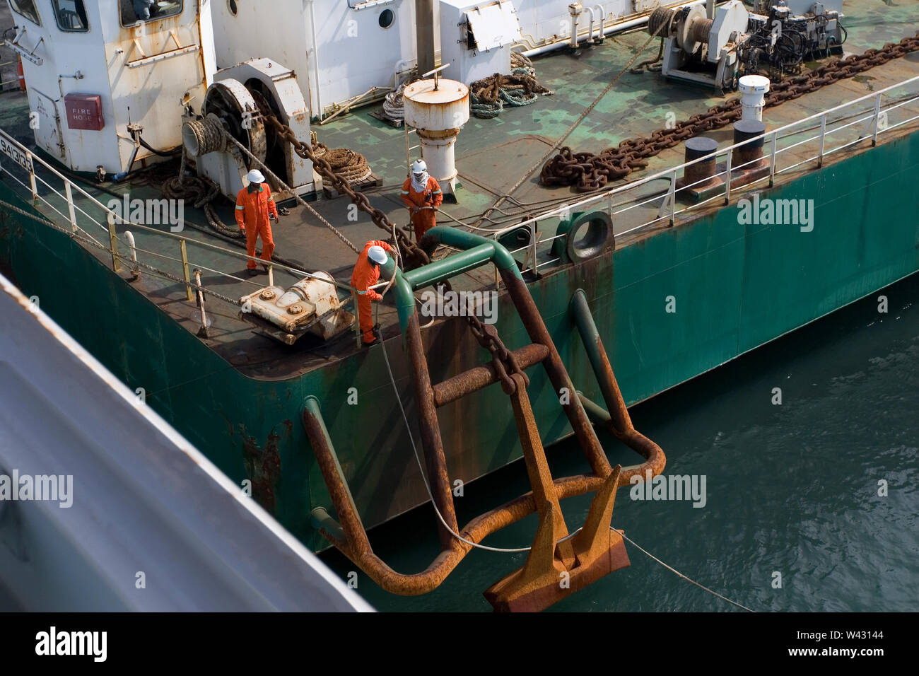 Bergbau, Verwaltung und Transport von Titanmineralsanden. Hafenanlage mit Barge Crew zieht Seil von Steg, so dass beladene Barge kann zu OGV segeln. Stockfoto