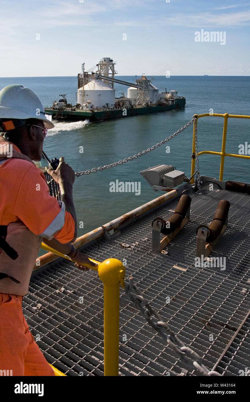 Bergbau, Verwaltung und Transport von Titanmineralsanden. Barge verlassen Hafen Anlegestelle, um Produkt in OGV auf See plus Lademaster auf Radio entladen Stockfoto