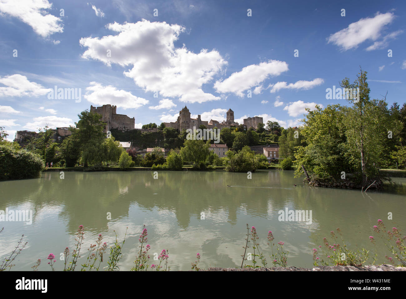 Chauvigny, Frankreich. Ein See in einem öffentlichen Garten mit die Ritterburg Ruinen, Donjon de Gouzon und Château d'Harcourt im Hintergrund. Stockfoto