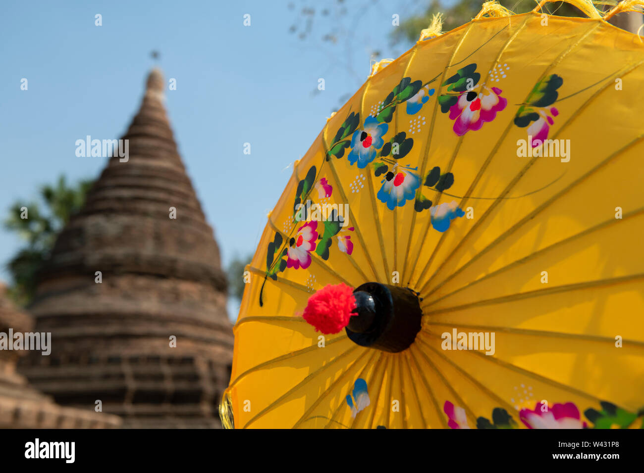 Bunte Straßenrand handbemalte souvenir Sonnenschirme mit traditionellen Tempel in der Ferne. Stockfoto