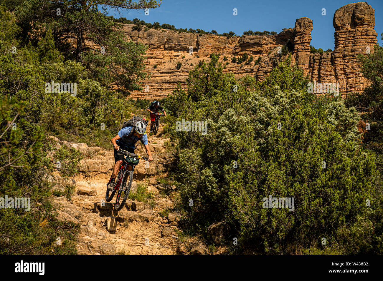 Zwei Männer fahren Mountainbikes hinunter einen steilen felsigen Trail in der Sierra de Guara Region der Pyrenäen Stockfoto