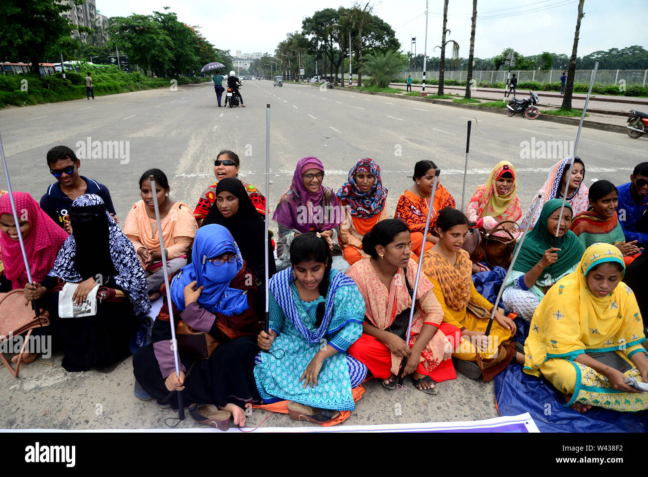 Bangladeshi visuell herausgefordert Absolvent Personal sitzen eine Straße bei einem Protest vor dem nationalen Parlament in Dhaka zu Am 10. Juli 2019, Stockfoto