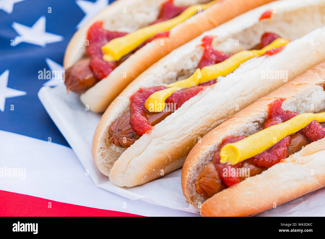 Typisch amerikanisches Fastfood: Hot Dogs und amerikanische Flagge. Nahaufnahme der Stereotypen uns Essen Stockfoto