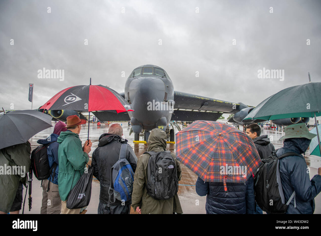 RAF Fairford, Glos, Großbritannien. Juli 2019 19. Tag 1 des Royal International Air Tattoo (RIAT) mit militärischer Flugzeuge aus der ganzen Welt Montage für größte Airshow der Welt, die vom 19.-21. Juli läuft. Tag 1 Flying Display ist stark durch die niedrige Wolkenuntergrenze, starker Regen und starkem Wind eingeschränkt. Bild: Statische Darstellung von militärischen Flugzeugen unter grauem Himmel und starker Regen. Sehr nass Besucher Untersuchen eines USAF-B-52. Credit: Malcolm Park/Alamy Leben Nachrichten. Stockfoto