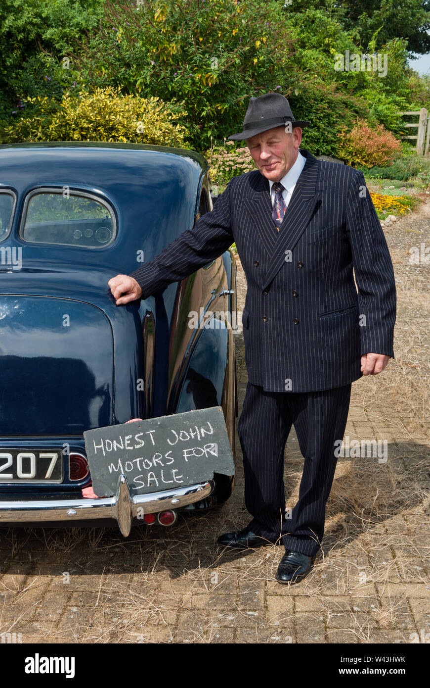 Mann im Kostüm der 1940er Jahre, der sich als Honest John, ein Gebrauchtwagenverkäufer, bei einer Veranstaltung im Milton Keynes Museum, Wolverton, Buckinghamshire, Großbritannien, posiert Stockfoto